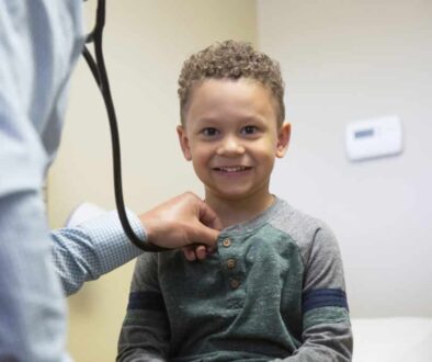 A child smile during his pediatric care appointment. Find the best pediatrician near you with Richfield Medical Group