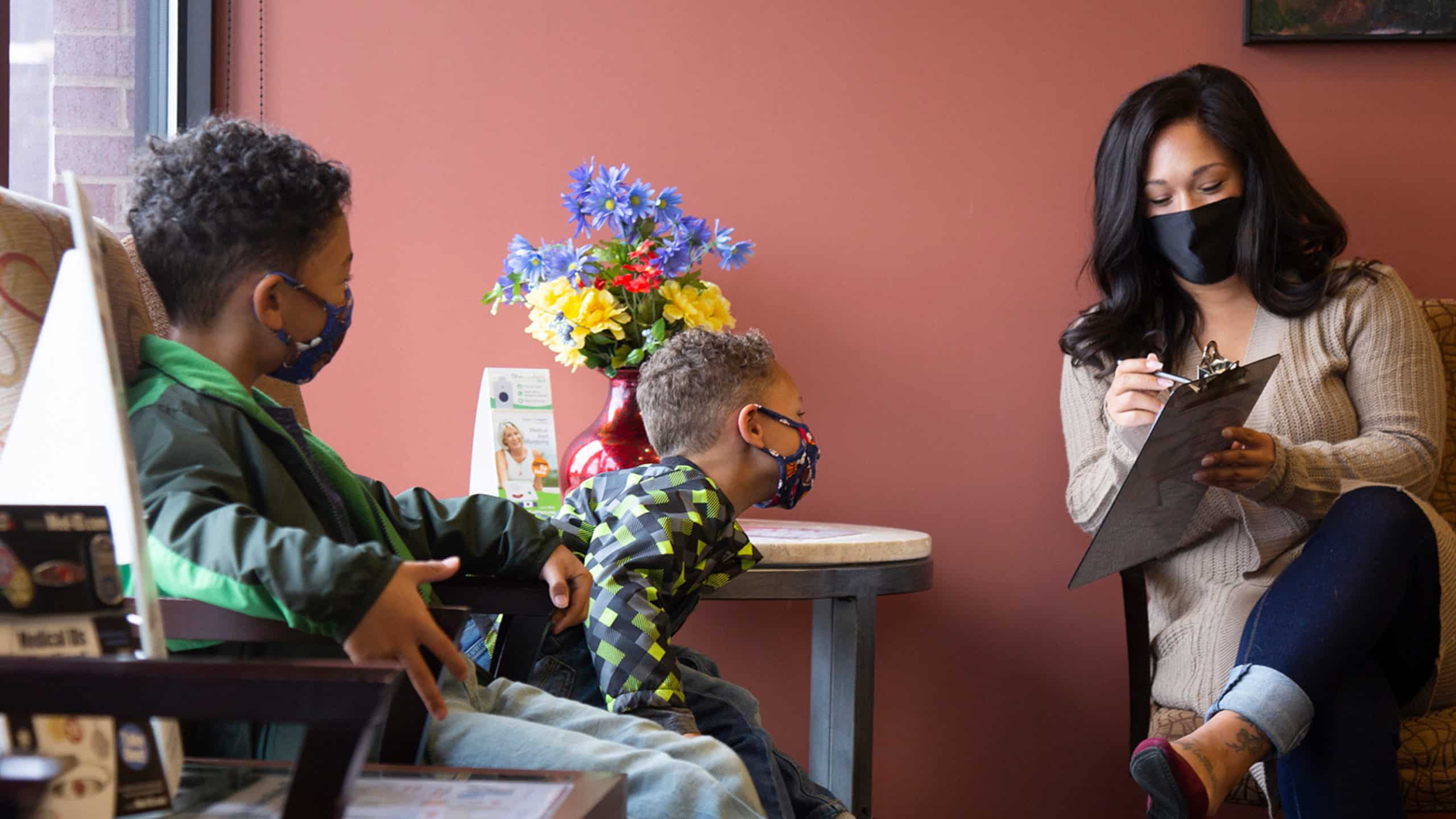 A mother schedules her next clinic visit for her children in the waiting room at Richfield Medical Group in Minnesota.
