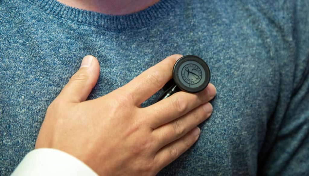 A Richfield Medical Group doctor holds a stethoscope to a patient's chest during a medical wellness screening