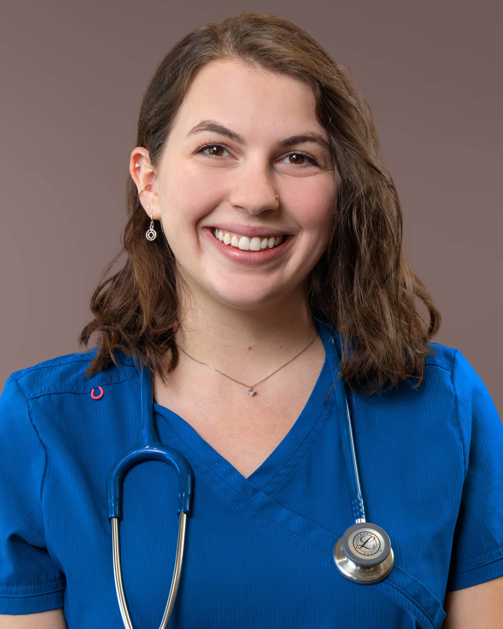 A nurse in blue scrubs with a stethoscope