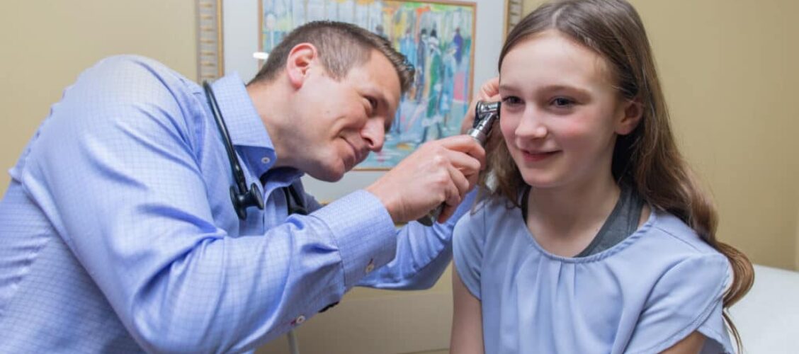 Doctor looking in a child's ear.