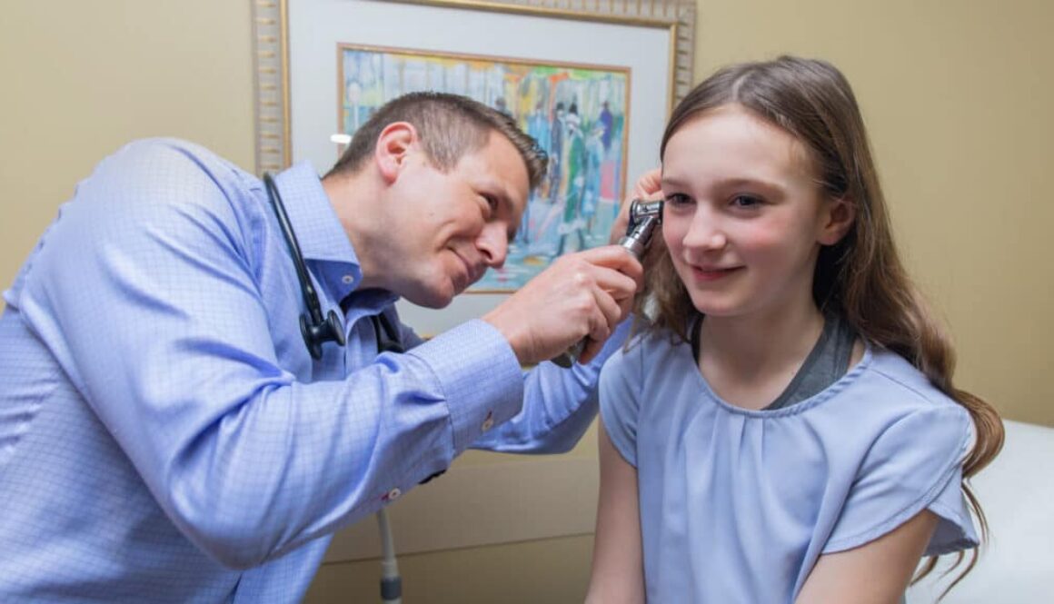 Doctor looking in a child's ear.